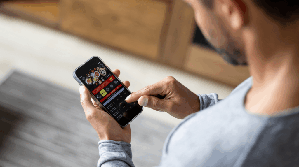 A man staring at a gambling app on his phone